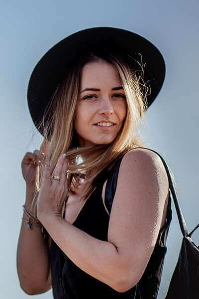 portrait image of a woman with black dress and a black hat